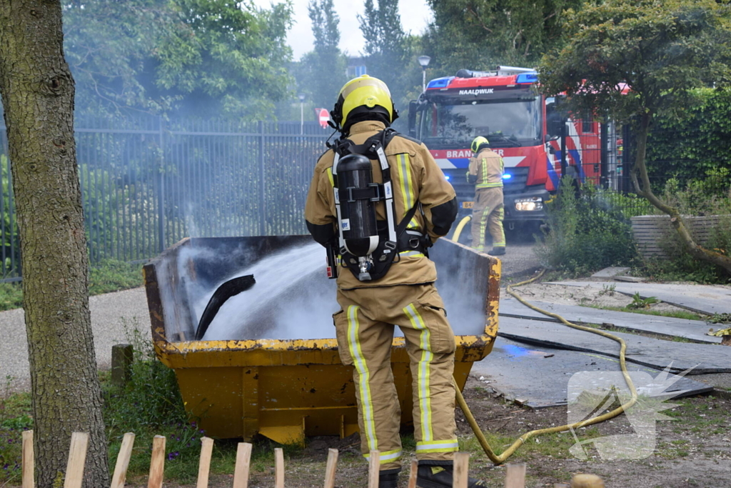 Brandweer blust brand in bouwcontainer