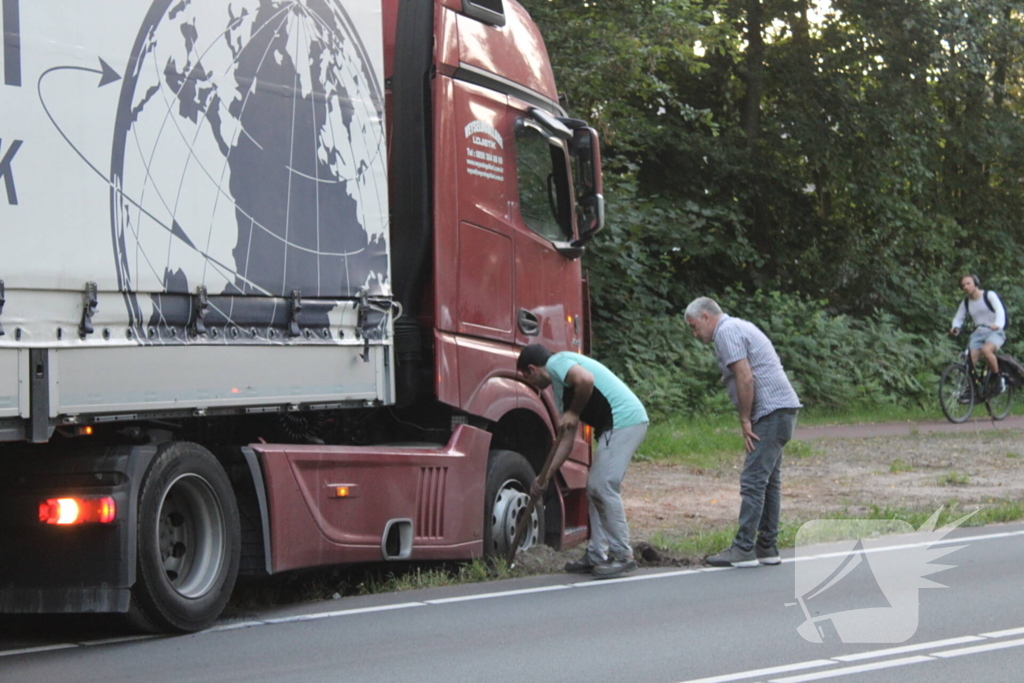 Vrachtwagen rijdt zich vast in berm