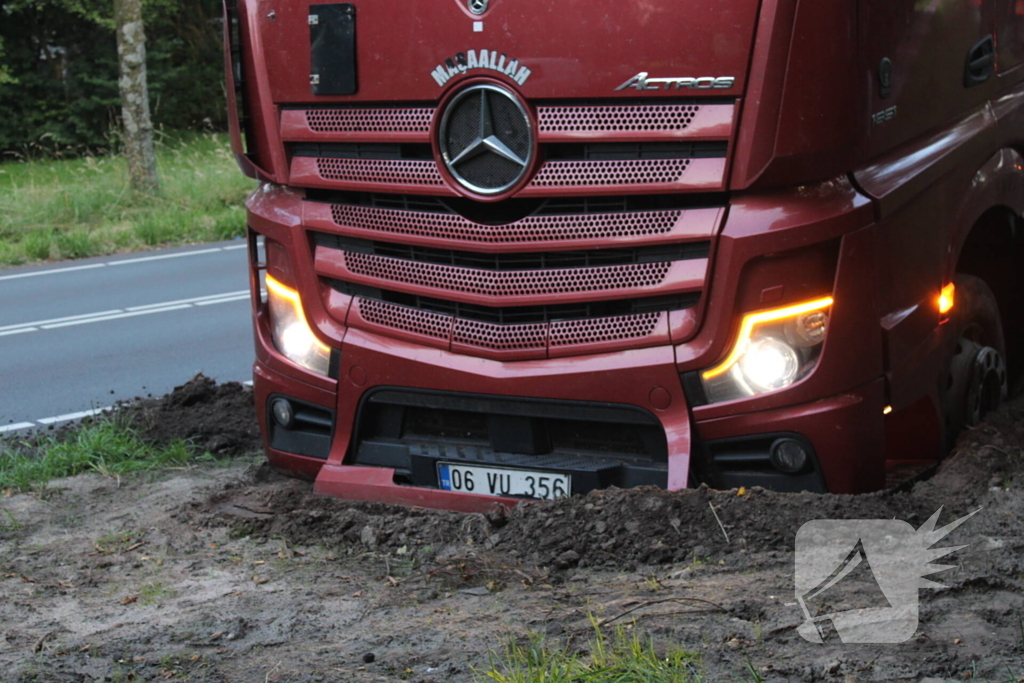 Vrachtwagen rijdt zich vast in berm