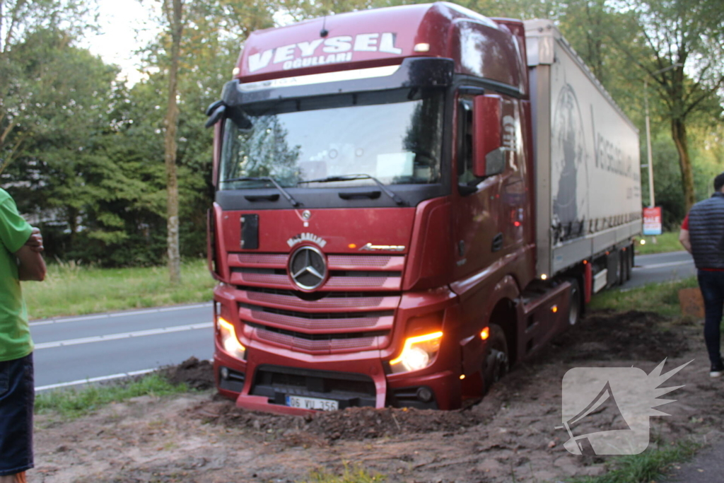 Vrachtwagen rijdt zich vast in berm