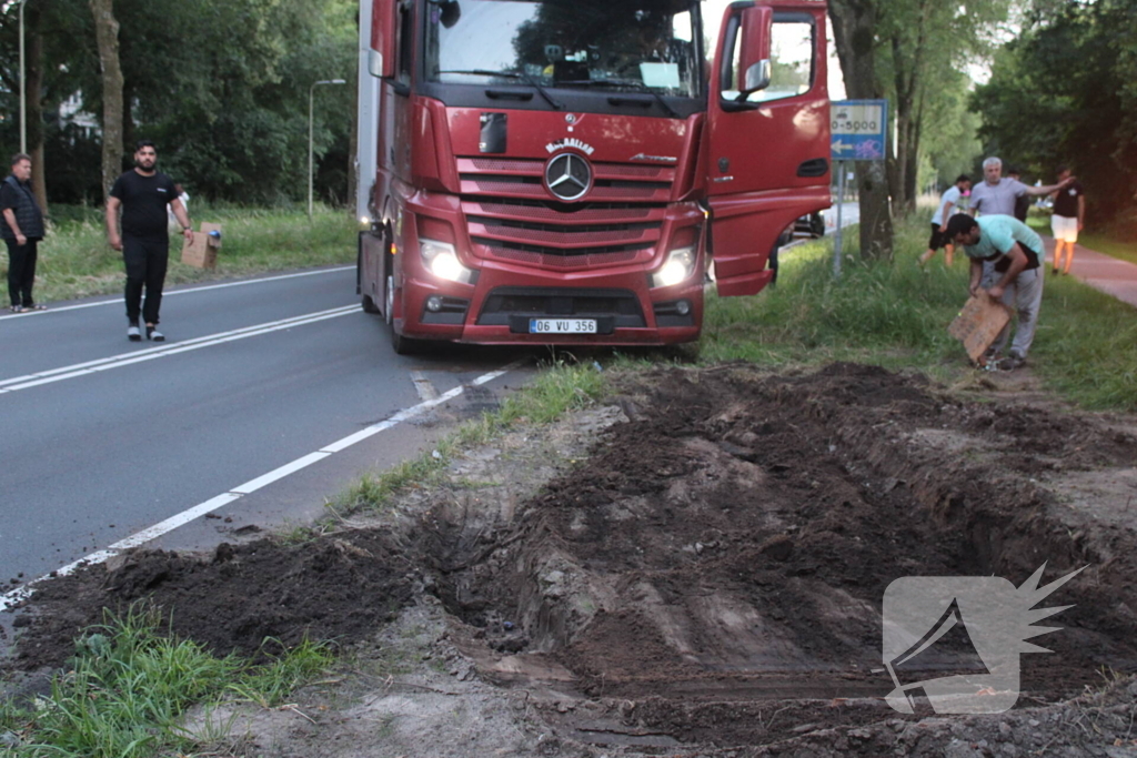 Vrachtwagen rijdt zich vast in berm