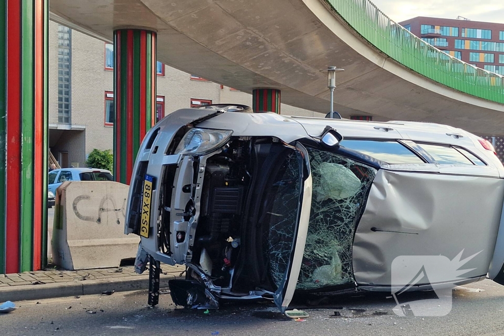 Auto belandt op zijkant, vrouw gewond