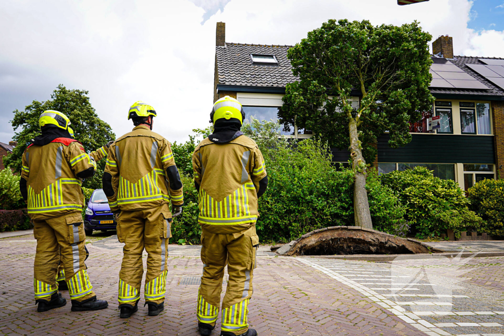 Boom valt tegen woning