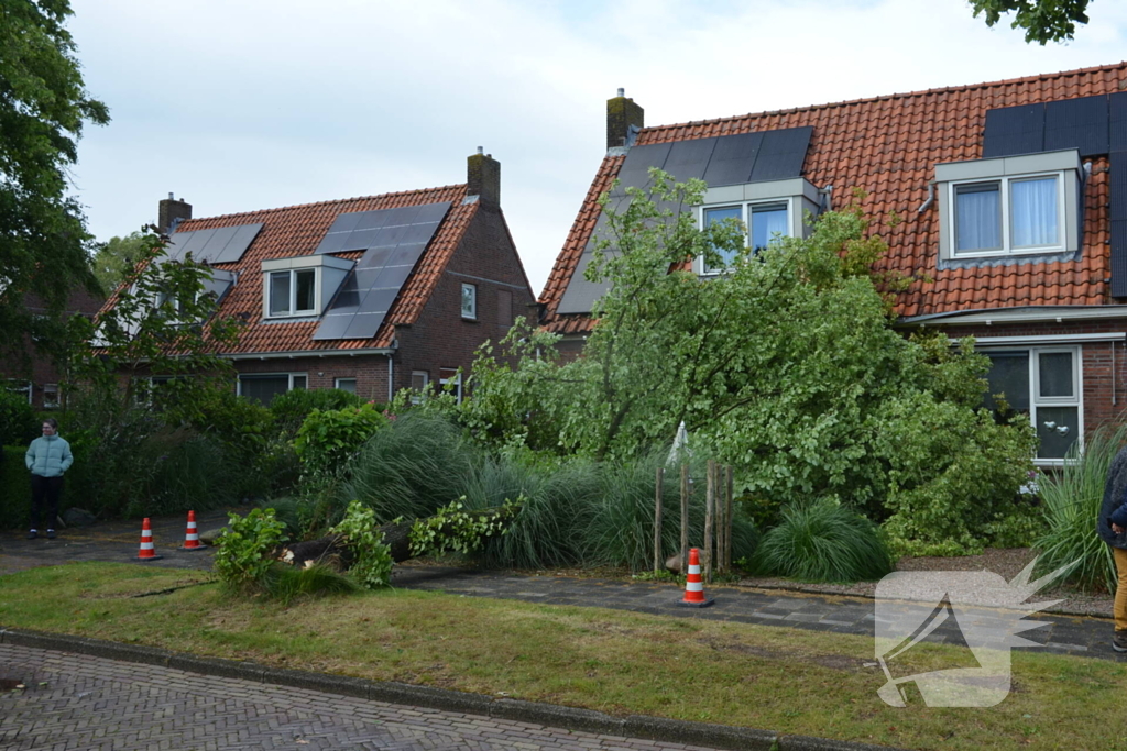 Omgewaaide boom valt tegen woning