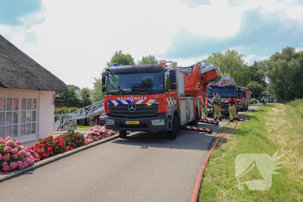 Brandweer blust brand in rietenkap van woning