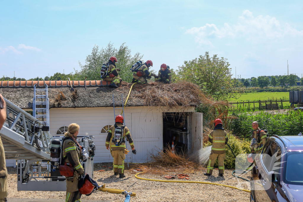 Brandweer blust brand in rietenkap van woning