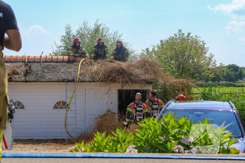 Brandweer blust brand in rietenkap van woning