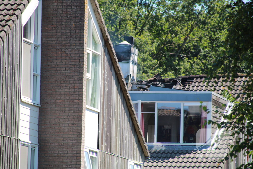 Brandweer blust brand in dak van woning