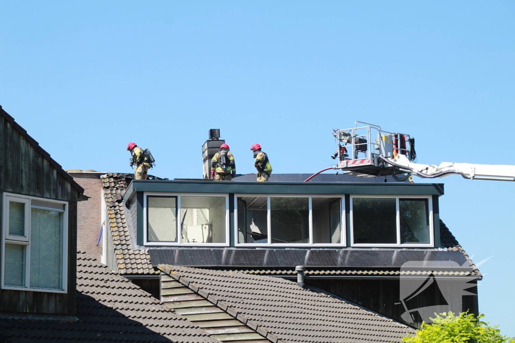 Brandweer blust brand in dak van woning