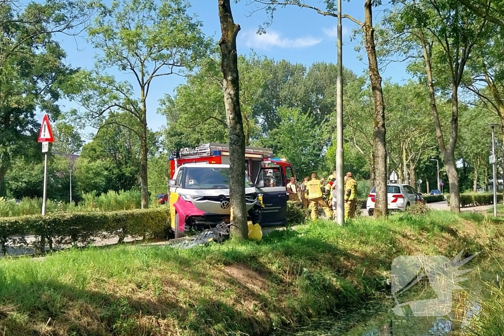 Elektrische bedrijfsbus raakt van de weg en belandt tegen boom