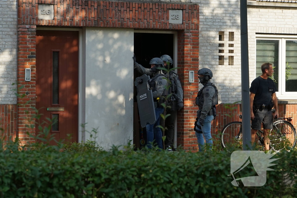 Agenten in kogelwerende vesten en Dienst Speciale Interventies bij inval in woning