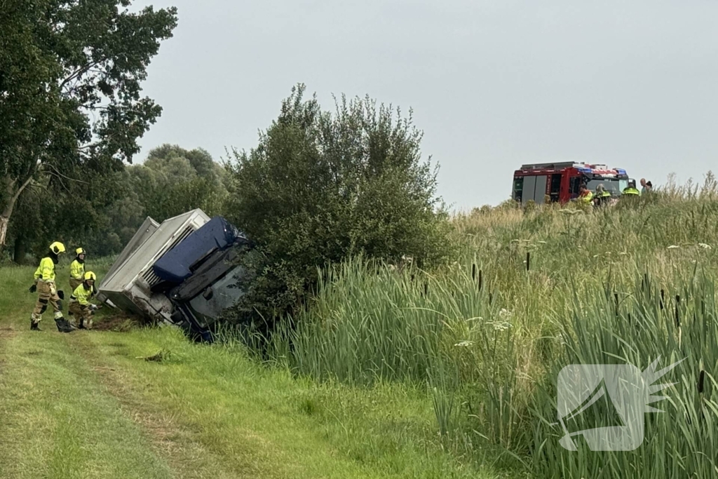 Vrachtwagen belandt in sloot naast snelweg, chauffeur ongedeerd