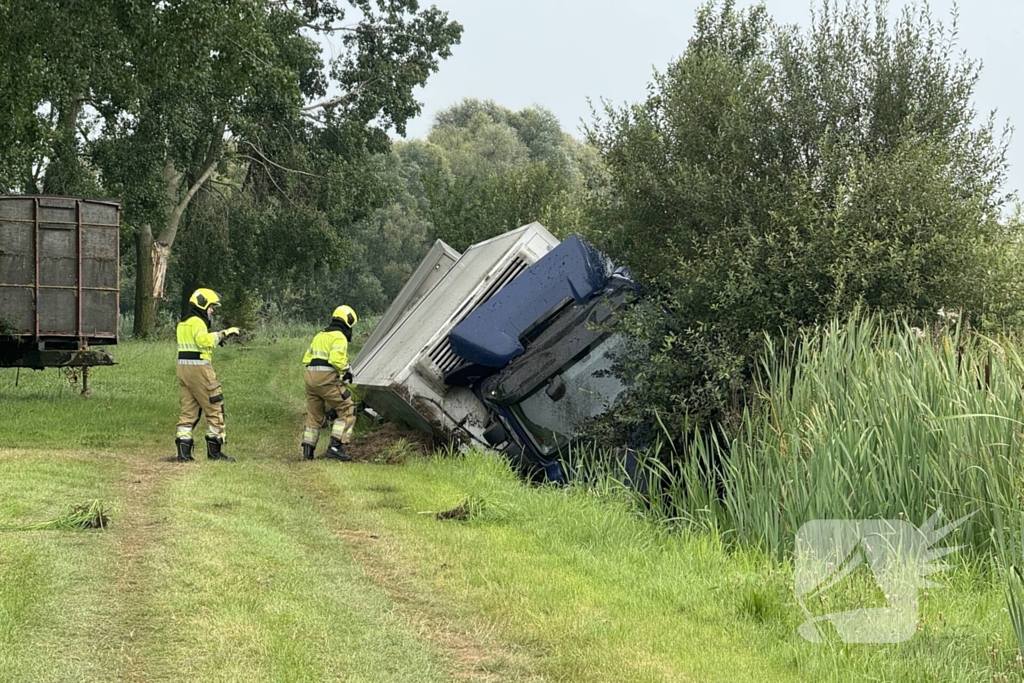 Vrachtwagen belandt in sloot naast snelweg, chauffeur ongedeerd