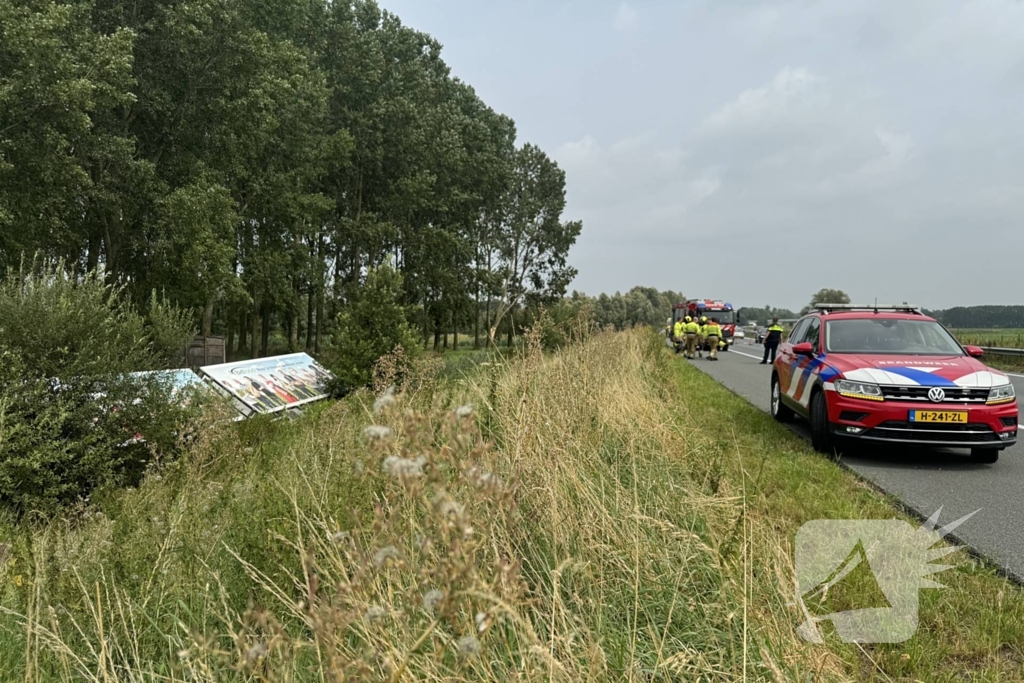 Vrachtwagen belandt in sloot naast snelweg, chauffeur ongedeerd