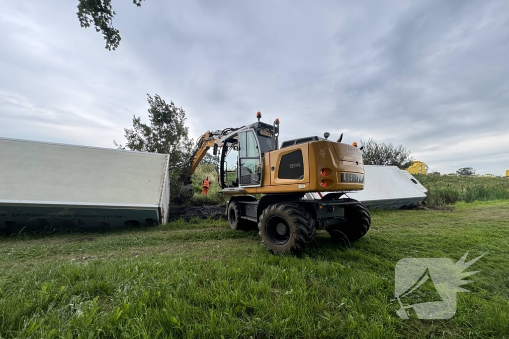 Vrachtwagen belandt in sloot naast snelweg, chauffeur ongedeerd