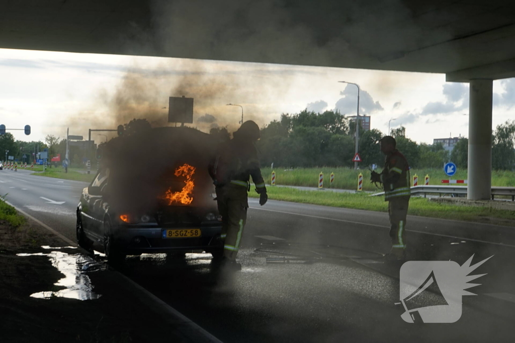 Brandweer blust brand onder motorkap