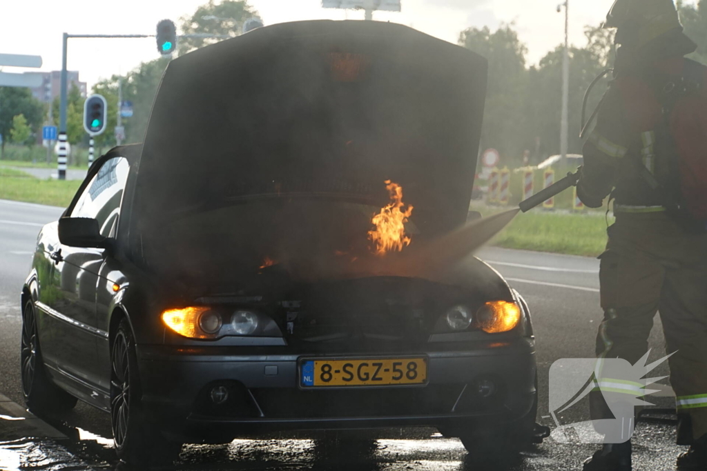 Brandweer blust brand onder motorkap