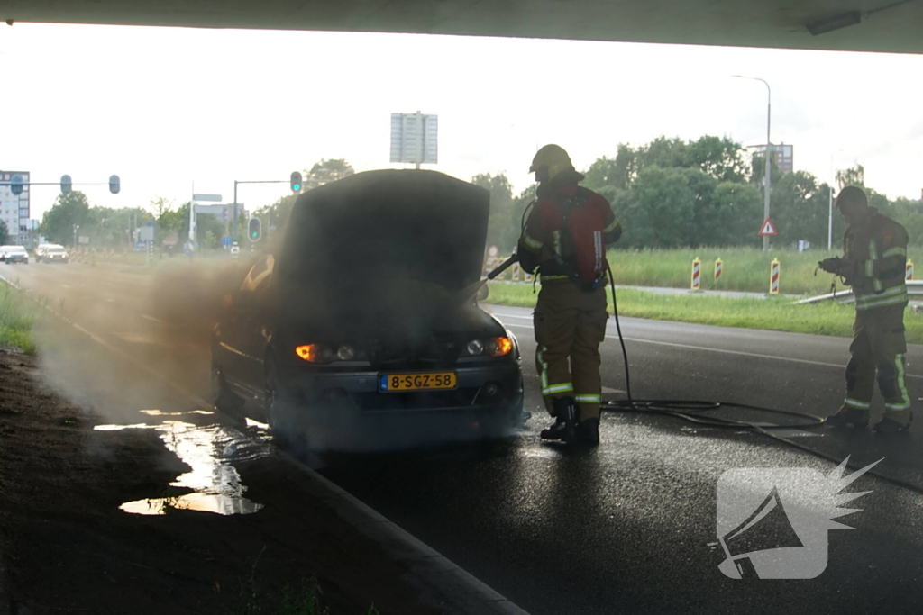 Brandweer blust brand onder motorkap