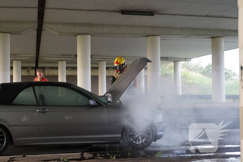 Brandweer blust brand onder motorkap