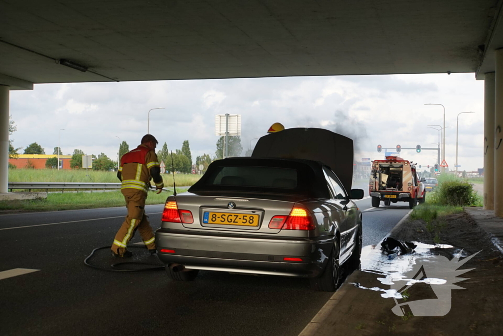 Brandweer blust brand onder motorkap