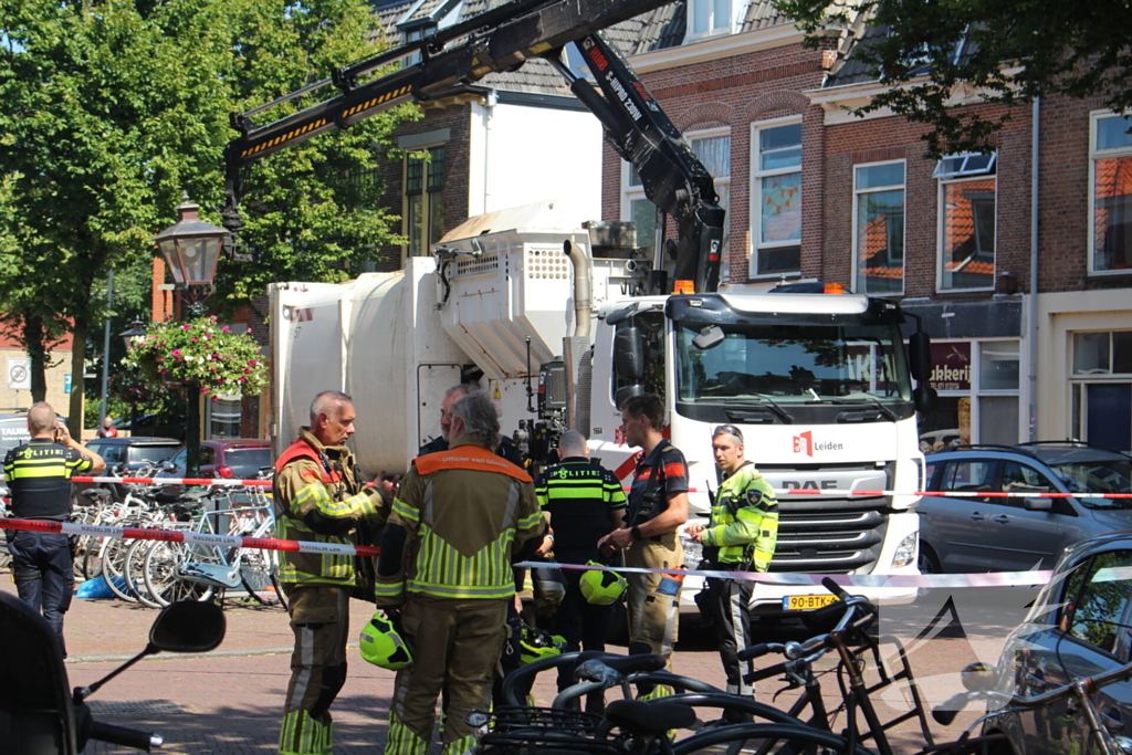 Vrouw belandt onder vuilniswagen