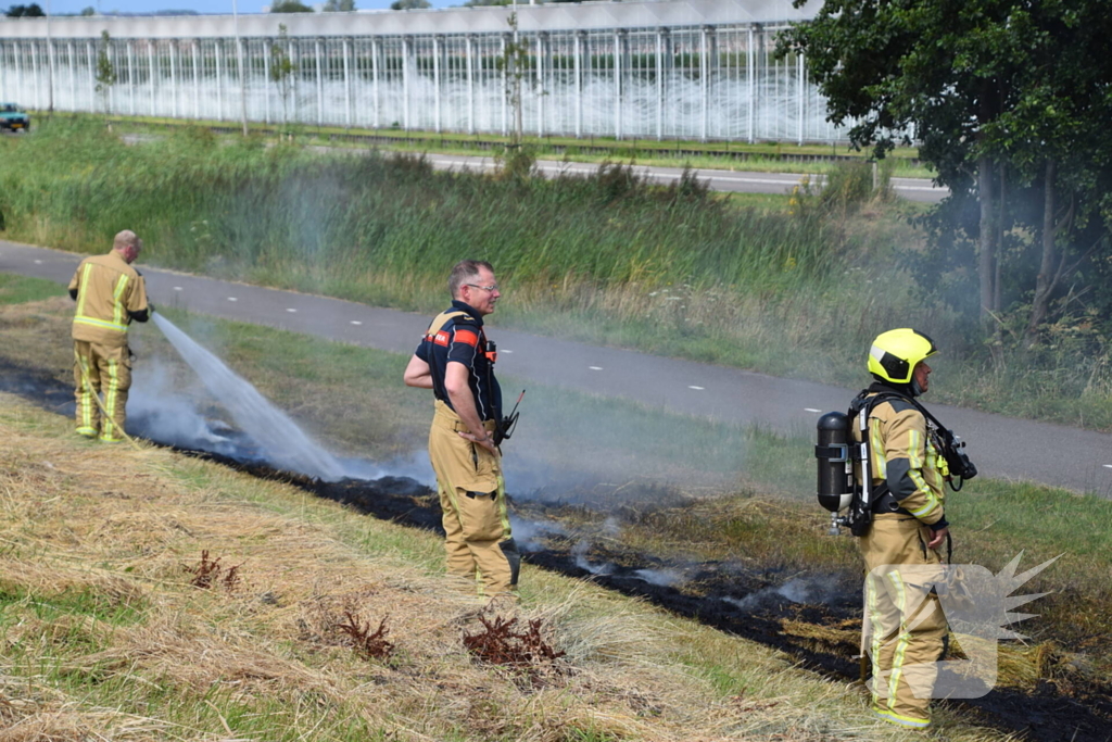 Tientallen meters berm in brand