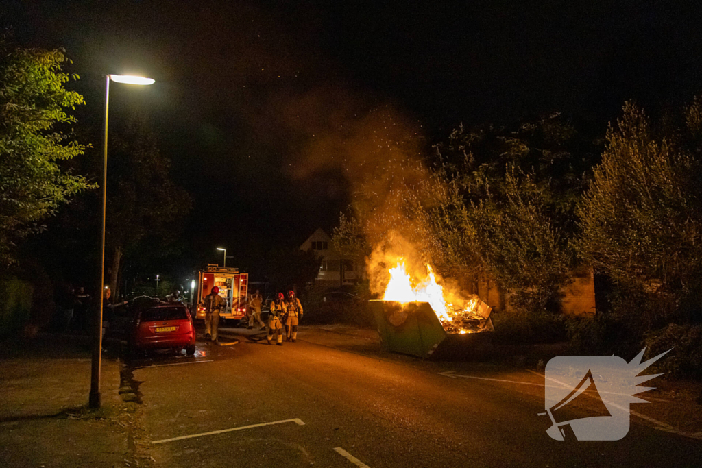 Metershoge vlammen door containerbrand