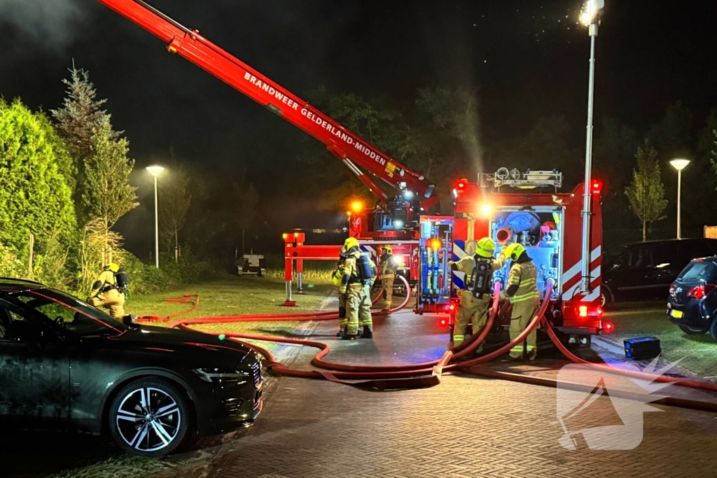 Vlammen slaan uit rietendak van woning