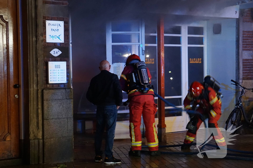 Brandweer blust brandende winkel