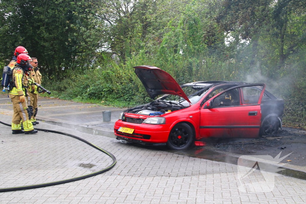 Brandweer blust brandende auto