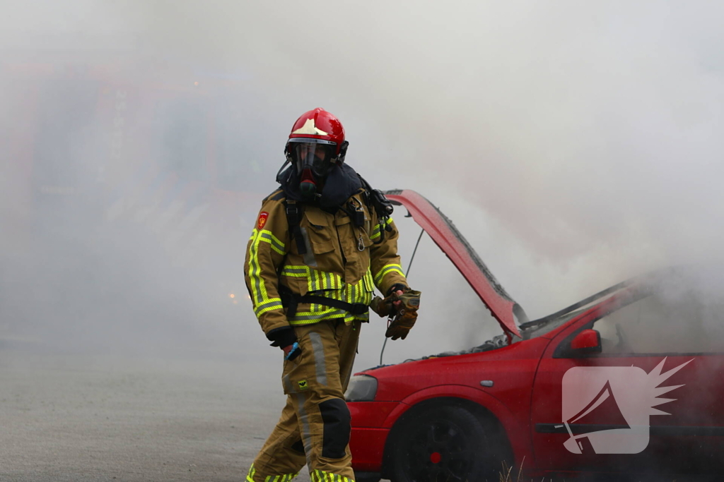 Brandweer blust brandende auto