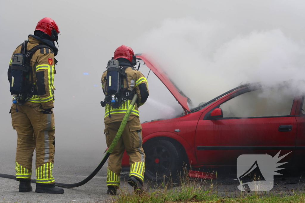 Brandweer blust brandende auto