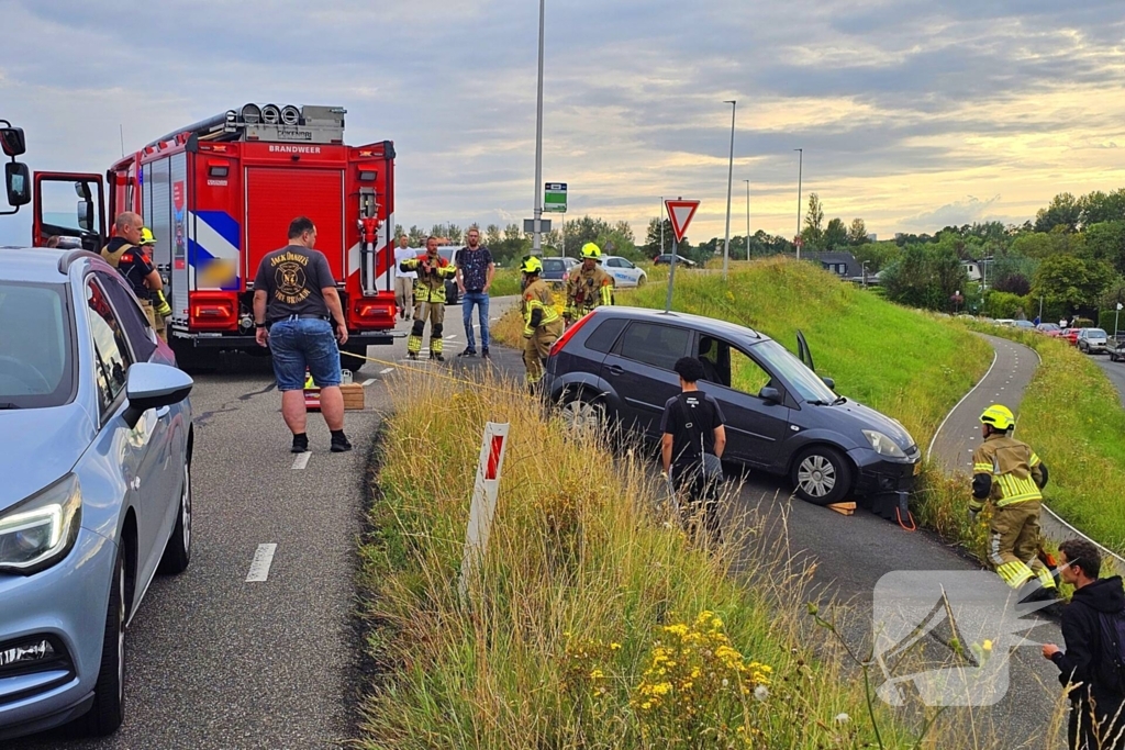 Brandweer trekt auto terug de dijk op