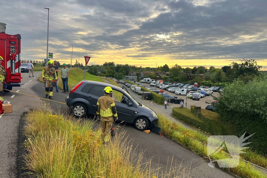 Brandweer trekt auto terug de dijk op