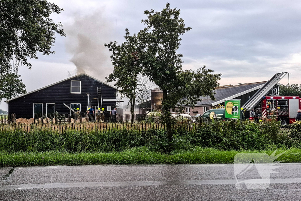 Brandweer blust brandende tussenmuur bij kaasboerderij