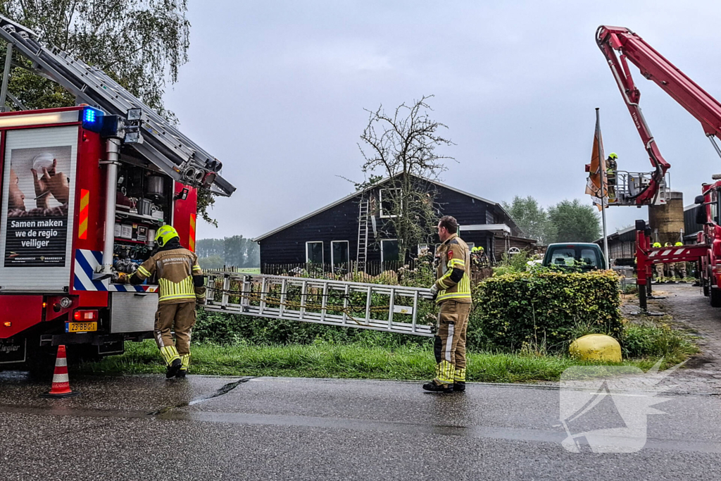 Brandweer blust brandende tussenmuur bij kaasboerderij