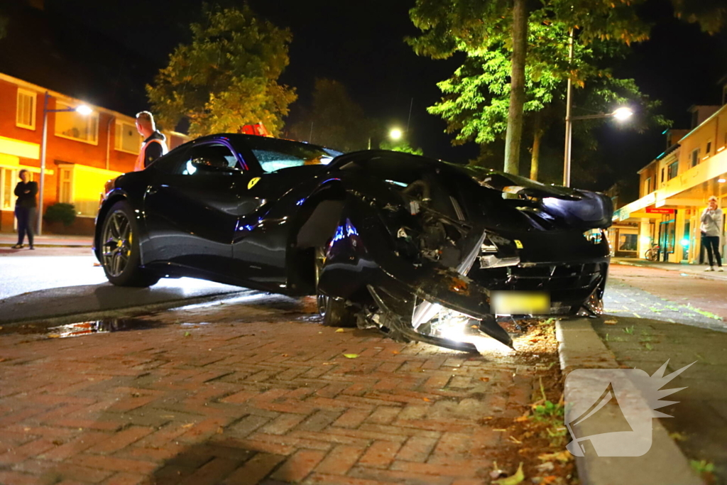 Ferrari klapt op boom en personenauto