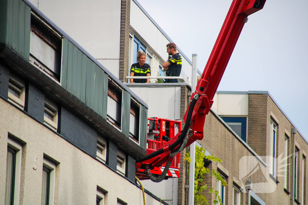 Veel rookontwikkeling bij brand op dak bij portiekwoning