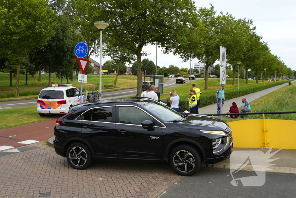 Scooterrijder komt ten val, ambulancepersoneel biedt hulp