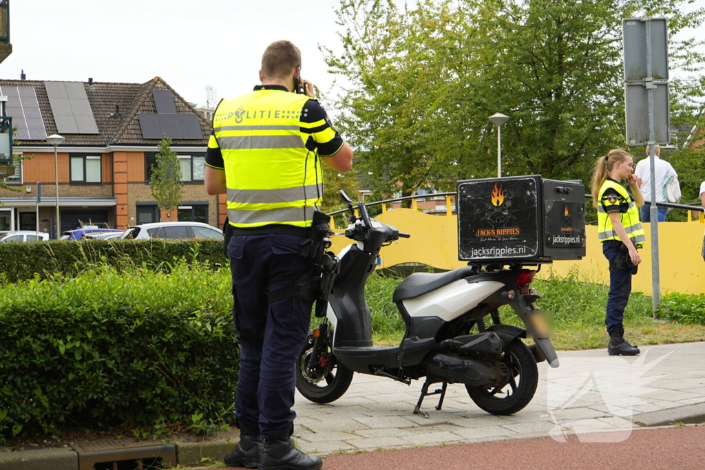 Scooterrijder komt ten val, ambulancepersoneel biedt hulp