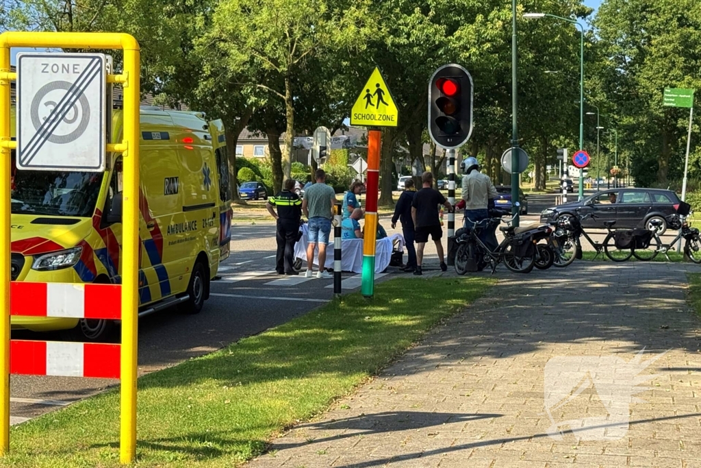 Ambulancemedewerkers behandelen gevallen snorfietser