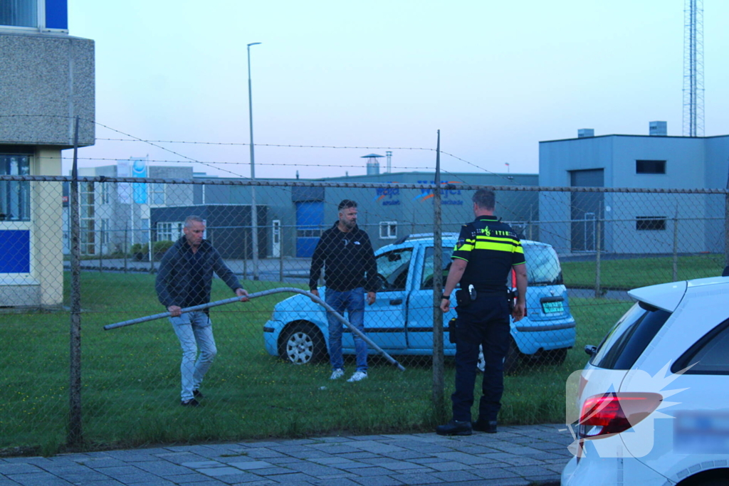 Personenauto rijdt door hek na botsing