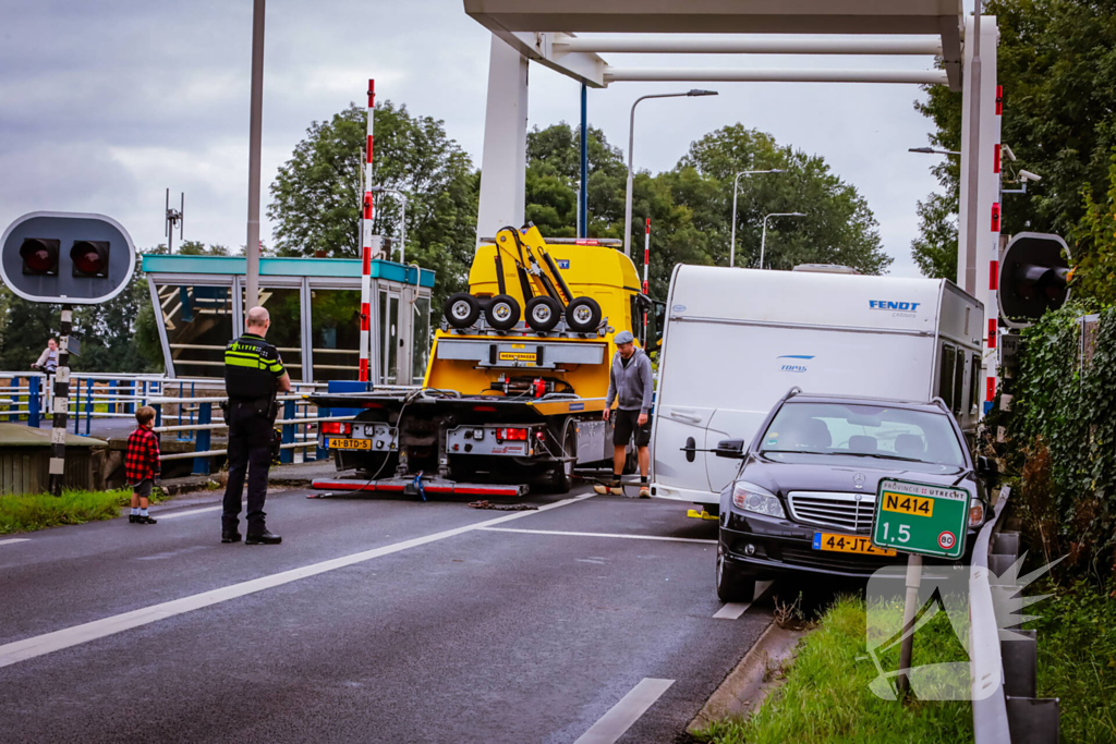 Auto met caravan belandt aan andere kant van weg