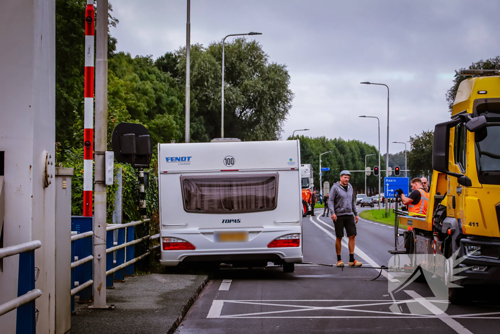 Auto met caravan belandt aan andere kant van weg