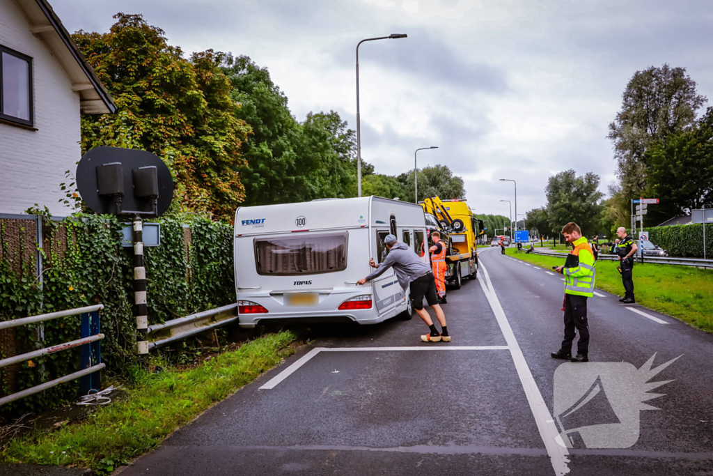 Auto met caravan belandt aan andere kant van weg