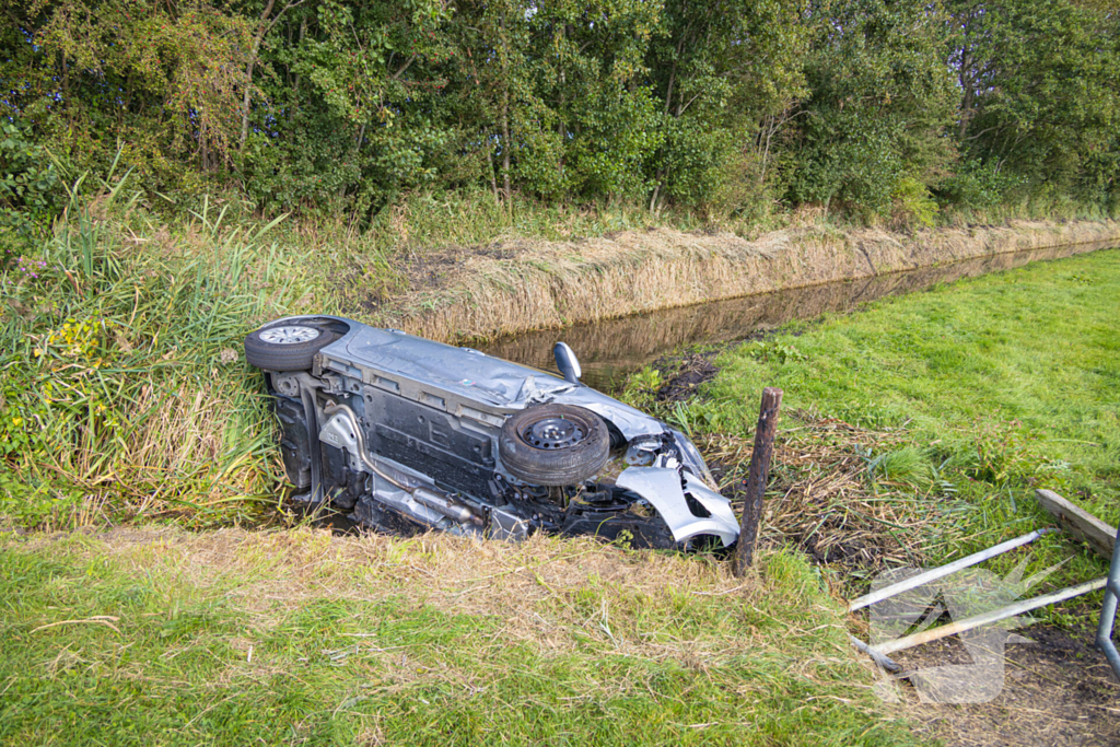 Omstanders halen automobilist uit te water geraakte auto