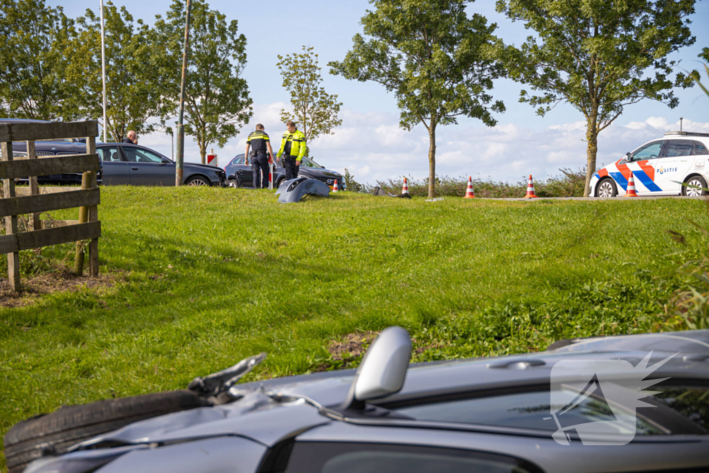 Omstanders halen automobilist uit te water geraakte auto