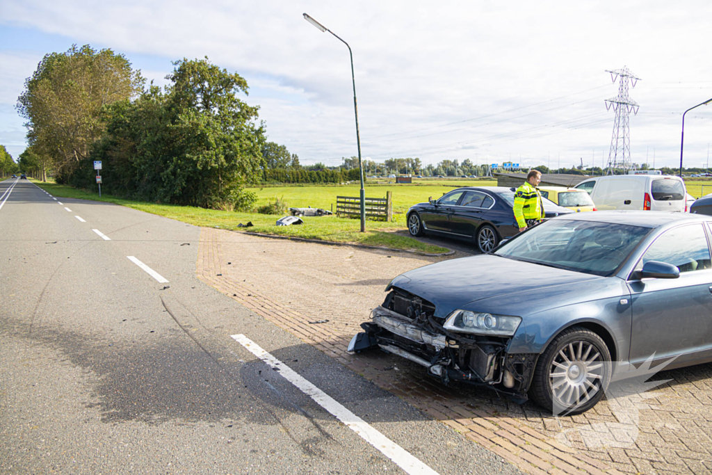 Omstanders halen automobilist uit te water geraakte auto