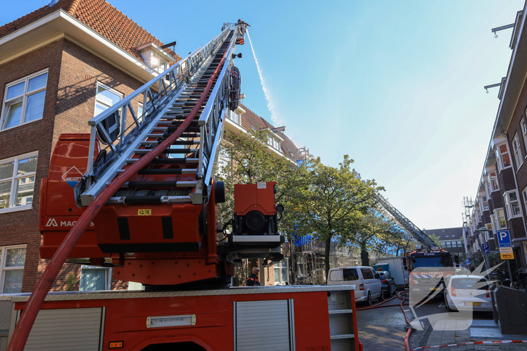 Zwarte rookwolken bij grote brand op dak van woning