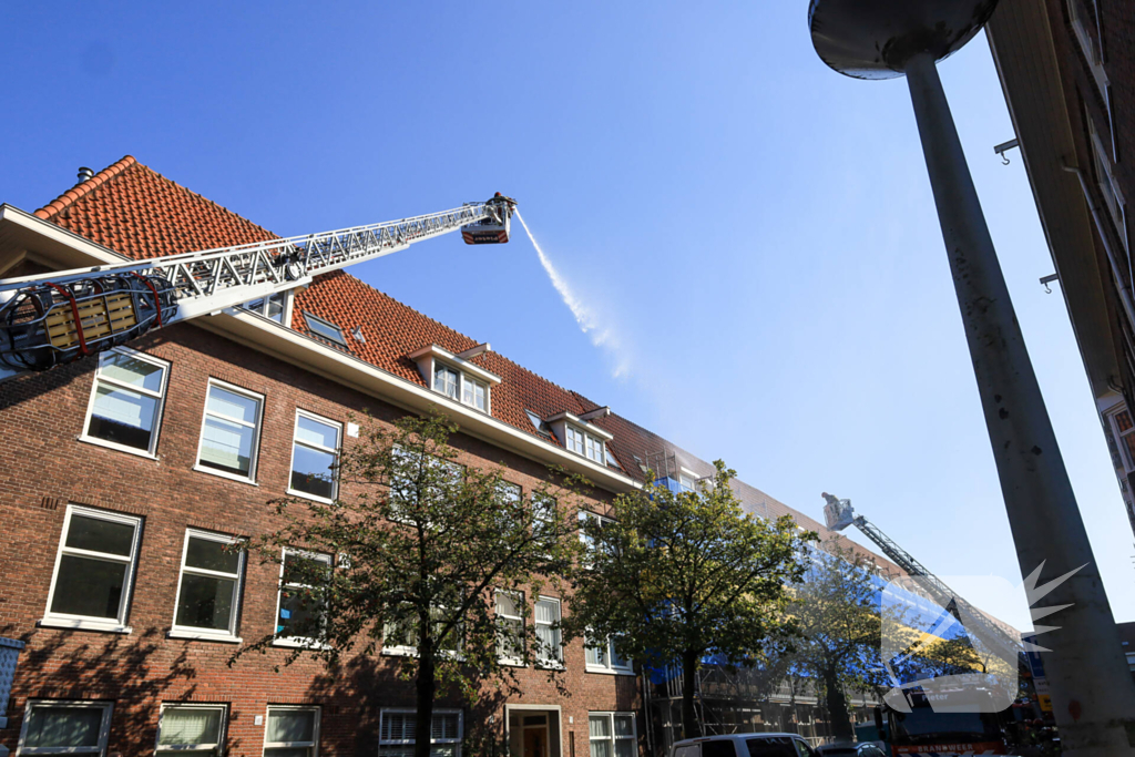 Zwarte rookwolken bij grote brand op dak van woning